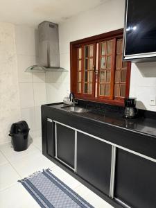 a kitchen with a sink and a counter top at Casa com Piscina em Itaipuaçu in Maricá