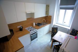 a kitchen with white cabinets and a stove and a table at Apartament Arpika in Ząbkowice Śląskie