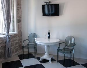 La salle de bains est pourvue de 2 chaises, d'une table et d'un lavabo. dans l'établissement Apartments Jasmina, à Korčula