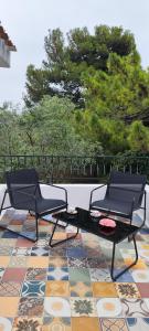 two chairs and a table on a tile floor at Il giardino di FraFa in Quartu SantʼElena