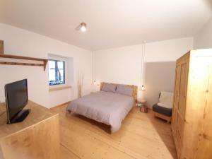 a bedroom with a bed and a flat screen tv at Casa MONTAGNA in Fai della Paganella