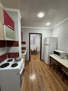 a small kitchen with a stove and a refrigerator at Tkacheva 14 in Pavlodar