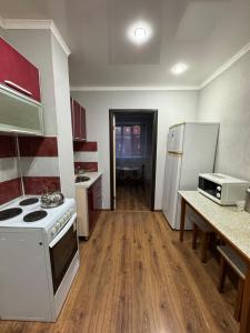 a small kitchen with a stove and refrigerator at Tkacheva 14 in Pavlodar