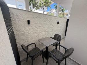 un tavolo e sedie su un balcone con muro di mattoni di Hotel Barjami a Sarandë