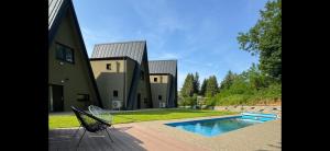 a house with a swimming pool in front of it at Domašovo in Holčíkovce