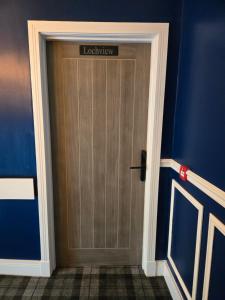 Lochview Apartment في تاربيت: باب خشبي عليه لافته في غرفه