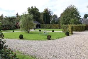 La Chapelle-sur-DunにあるLa Vienne - Domaine du presbytèreの芝生の中にテーブルと椅子が置かれた庭園