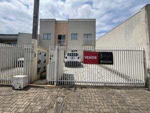 a white fence in front of a building at Apartamento Confortável com Área Gourmet in Fazenda Rio Grande