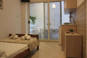 a bedroom with a bed and a view of a balcony at Sunray Studios Asprovalta in Asprovalta