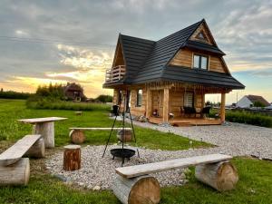 a small log cabin with a swing and benches at Domek Sumigoj w Chochołowie in Chochołów