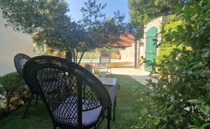 a patio with two chairs and a table in a yard at Apartment Carpe Diem Ivan Dolac in Ivan Dolac