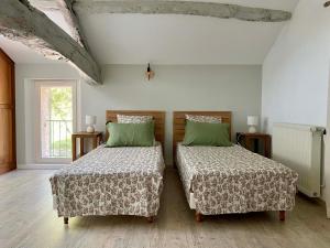 two beds sitting in a room with at Le chant des Loriots in Bajamont