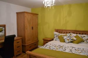 a bedroom with a bed and a dresser and a chandelier at Glendarragh Cottage in Cushendall