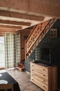 Bartusiowa Osada في زاكوباني: غرفة معيشة مع درج مع تلفزيون على خزانة