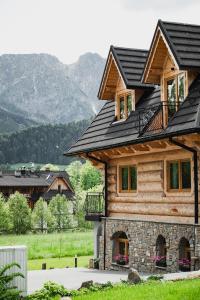 Bartusiowa Osada في زاكوباني: منزل خشبي مع سقف أسود