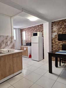 a kitchen with a white refrigerator and a table at Villa Sun & Sea in Constanţa