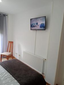 a bedroom with a bed and a tv on the wall at Residencial Covabella confortllanes in Posada de Llanes +7 photos