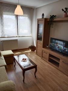 a living room with a couch and a coffee table at Residencial Covabella confortllanes in Posada de Llanes
