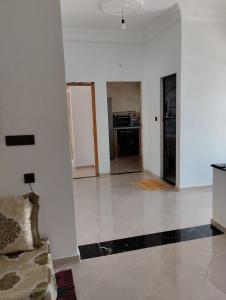 an empty living room with a couch and a kitchen at Belle maison près de la plage in Chefchaouene +1 photo