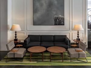 a living room with a couch and a table and chairs at Radisson Blu Hotel, London Bloomsbury in London