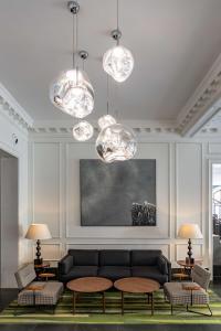 a living room with a couch and chandeliers at Radisson Blu Hotel, London Bloomsbury in London
