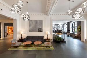 a living room with a couch and tables and lights at Radisson Blu Hotel, London Bloomsbury in London