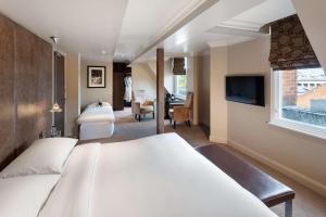 a hotel room with two beds and a television at Radisson Blu Hotel, London Bloomsbury in London