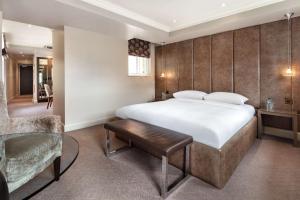 a hotel room with a large bed and a chair at Radisson Blu Hotel, London Bloomsbury in London