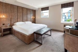a bedroom with a large bed and a desk at Radisson Blu Hotel, London Bloomsbury in London