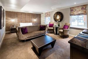 a living room with a couch and a table at Radisson Blu Hotel, London Bloomsbury in London