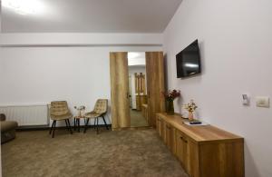 a living room with a television and two chairs at Alemar Mamaia Nord in Năvodari