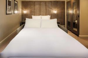 a large white bed in a hotel room at Radisson Blu Hotel, London Bloomsbury in London