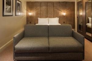 a couch in a room with a bed at Radisson Blu Hotel, London Bloomsbury in London