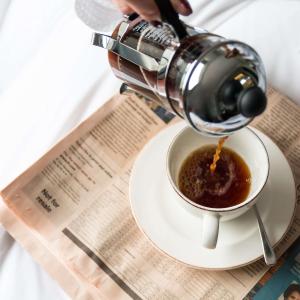 a person pouring coffee into a cup on a table at Radisson Blu Hotel, London Bloomsbury in London