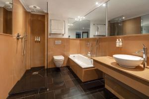 a bathroom with a sink and a toilet and a mirror at Radisson Blu Hotel, London Bloomsbury in London +37 photos