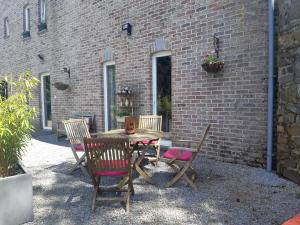 a wooden table and chairs next to a brick wall at La Maison des Senteurs in Francorchamps +191 photos
