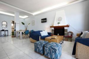a living room with blue furniture and a fireplace at Villa Violeta Lefkada Nydri in Nydri