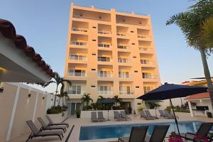 a hotel with a pool and chairs and a building at Costa Paraíso D-17 Estudio in Bucerías