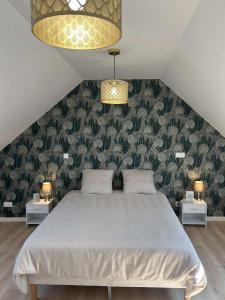 Un dormitorio con una cama grande con una pared verde. en Le Mans'ardé, en Le Mans