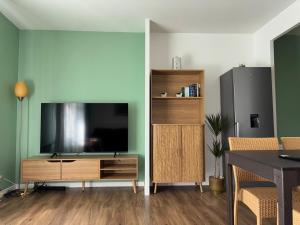 a living room with a large television and a table at Cosy Disney Escape - 3 min Disney - 35 min Paris in Chessy