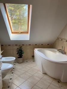 a bathroom with two sinks and a tub and a window at Relax in Tlen in Tleń