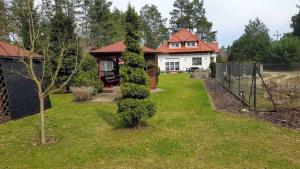 a house with a tree in the yard at Relax in Tlen in Tleń