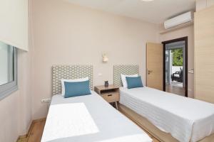a bedroom with two beds and a window at Villa Piedra Acharavi in Acharavi