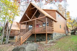 a large log cabin with a deck and stairs at Rhythm & Blues By Avada Properties in Gatlinburg