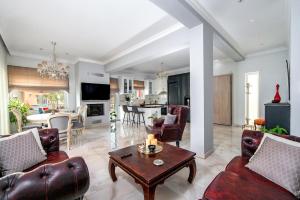 Una sala de estar con sofás y una mesa y una cocina. en Evis coastal comfort house, en Kalamaki