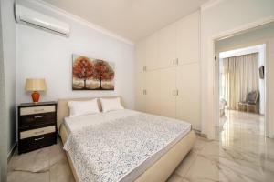 Un dormitorio blanco con una cama y un cuadro en la pared. en Evis coastal comfort house, en Kalamaki