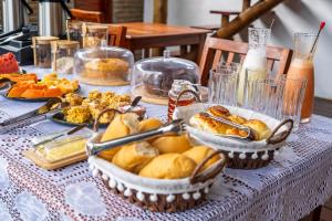 a table topped with baskets of bread and other food at Pousada no Mar in Icaraí