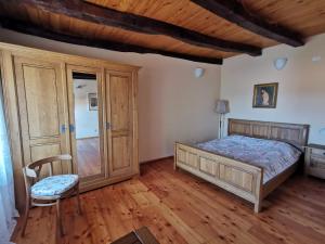 a bedroom with a bed and a chair and wooden floors at Domus Carstica in Sežana