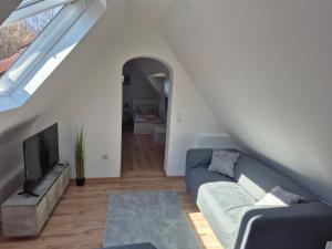 a living room with a couch and a tv at Schumacher Ferienwohnung in Netphen