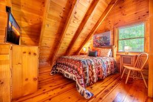 een slaapkamer met een bed in een blokhut bij Quiet Way Cabin By Avada Properties in Sevierville